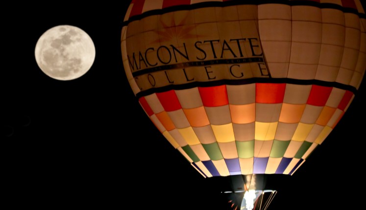 Hot air balloon with Macon State College floating in a moonlit sky